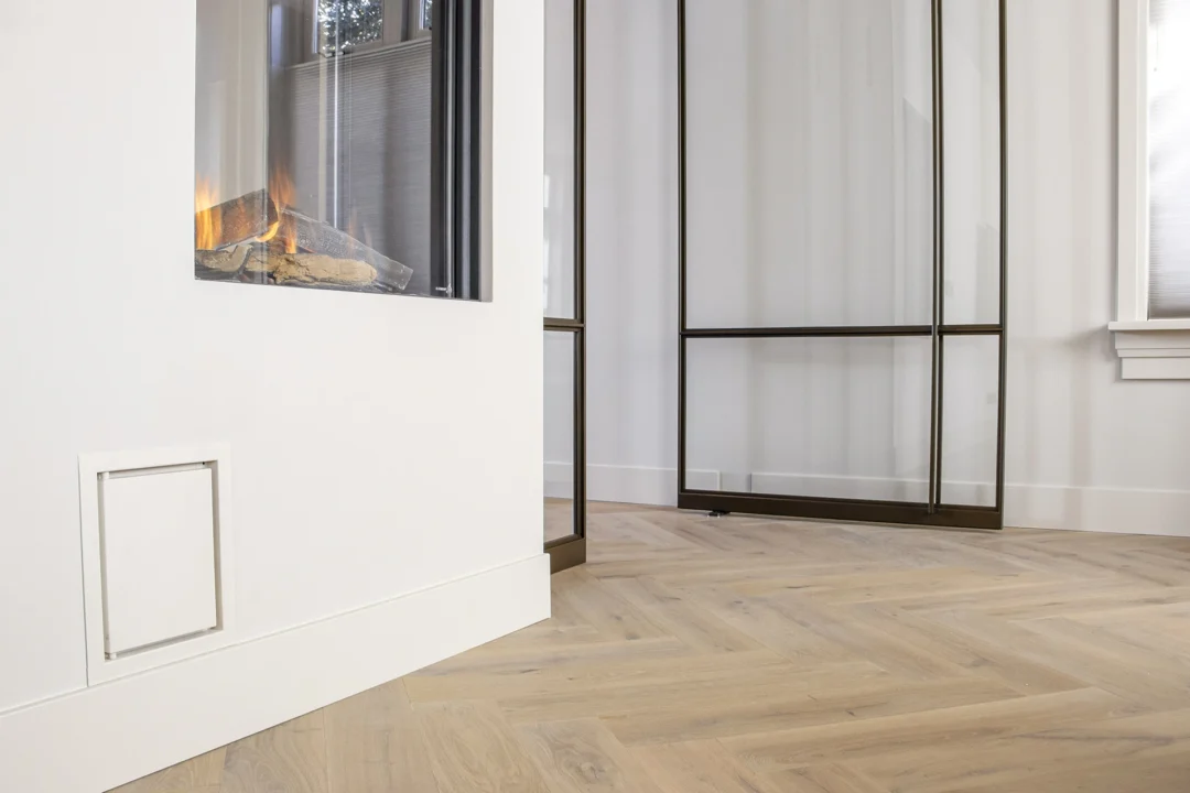 Stalen deuren en houten visgraatvloer creëren stijlvol contrast in het interieur