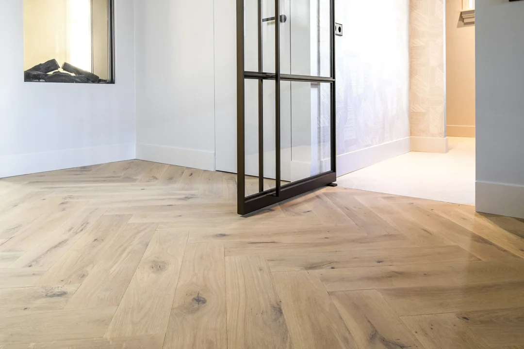 Stalen deur tussen keuken en hal boven rustieke houten vloer